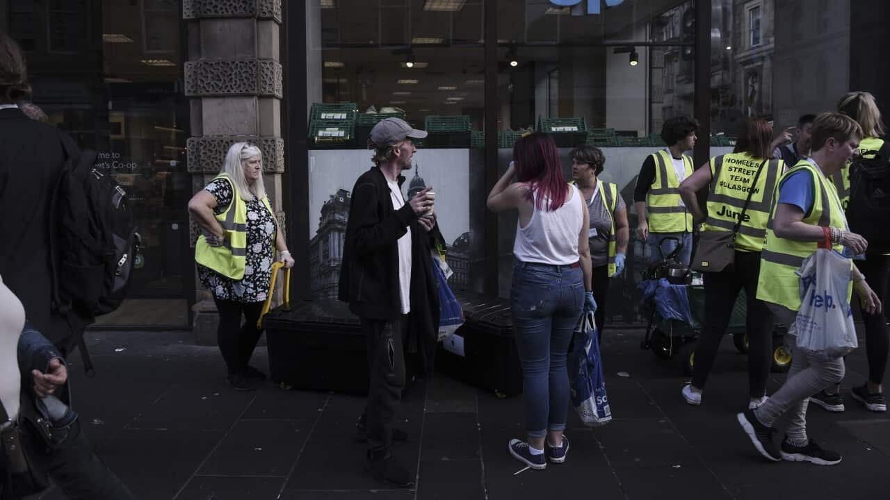 James Muir receives tea and clothing from Homeless Street Team Glasgow, a volunteer group, in the city center of Glasgow, Scotland, July 23, 2019. (Mary Turner/The New York Times)