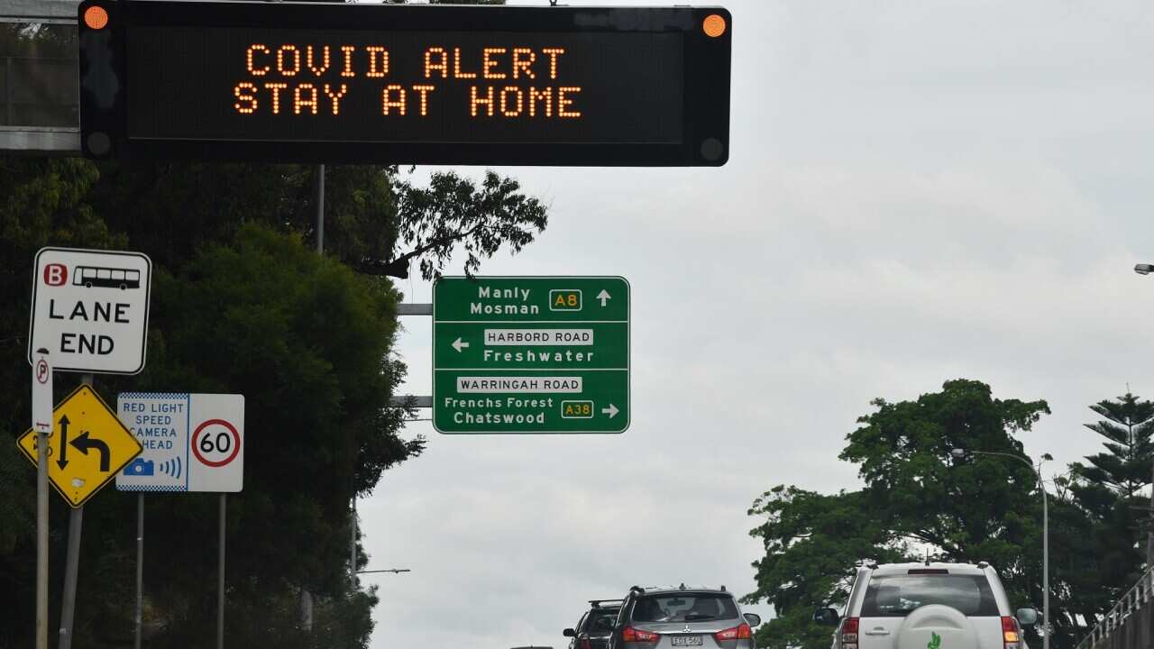 A sign on Pittwater Road instructs residents and visitors to stay home in the northern beaches of Sydney