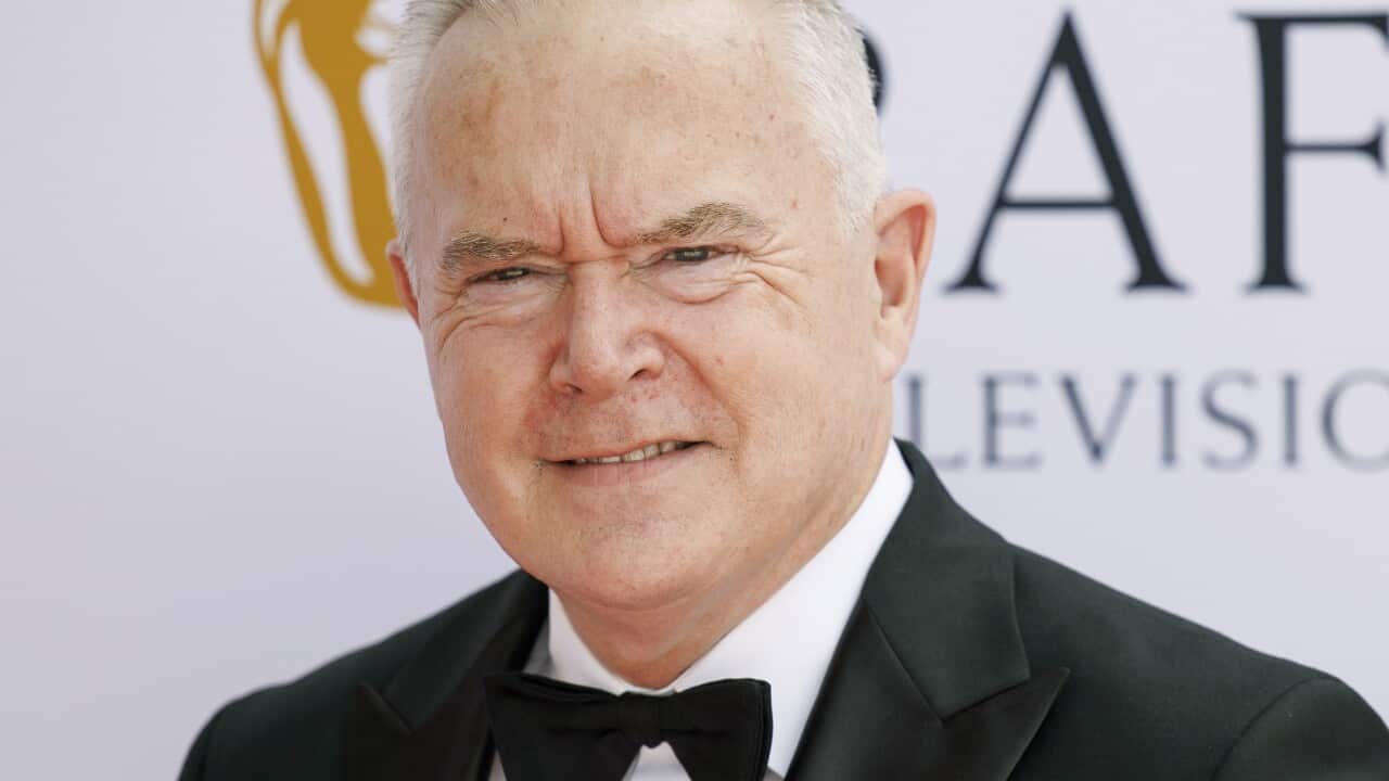 A man wearing a tuxedo looking at the camera.