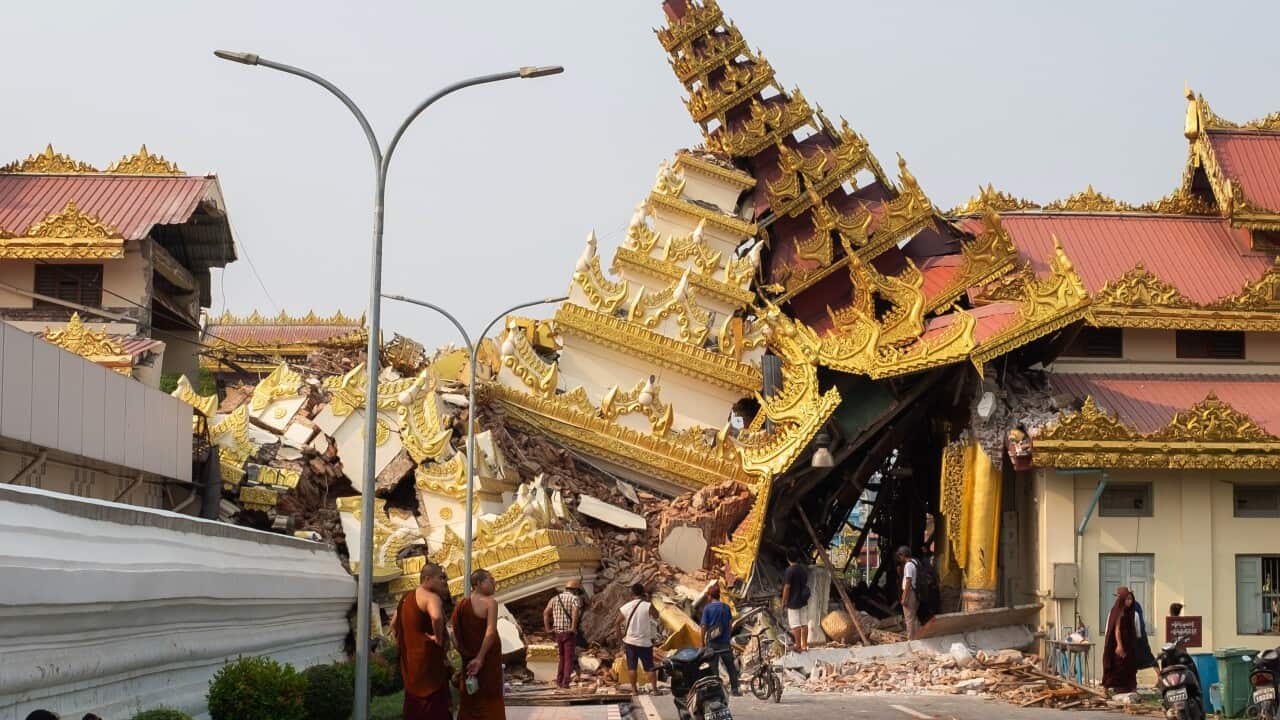 A crowd of people looking at a collapsed ornate gold temple