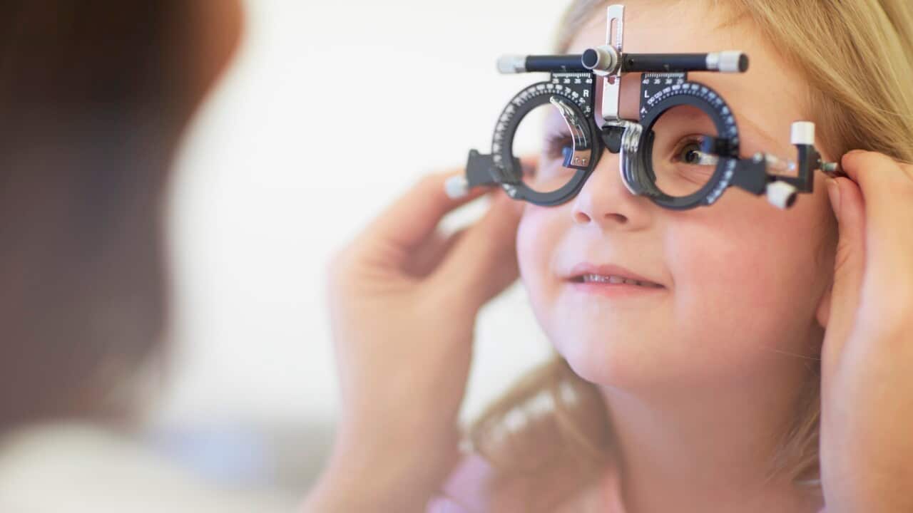 Eye doctor examining girl's vision