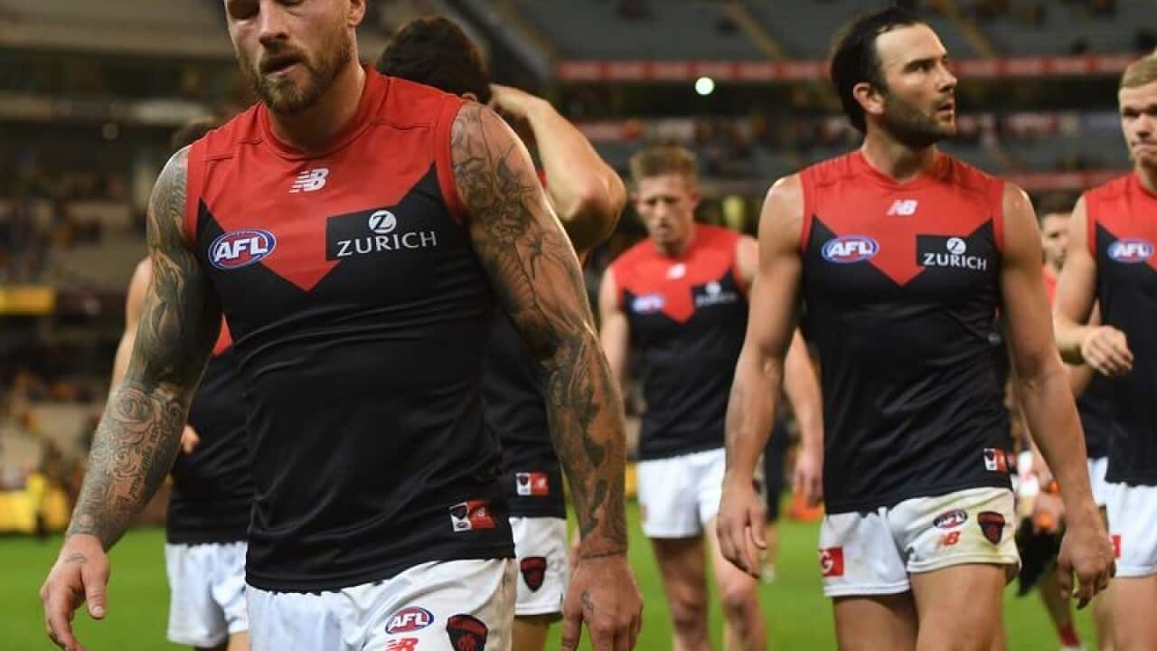 Nathan Jones of the Demons (left) leads his players from the field.