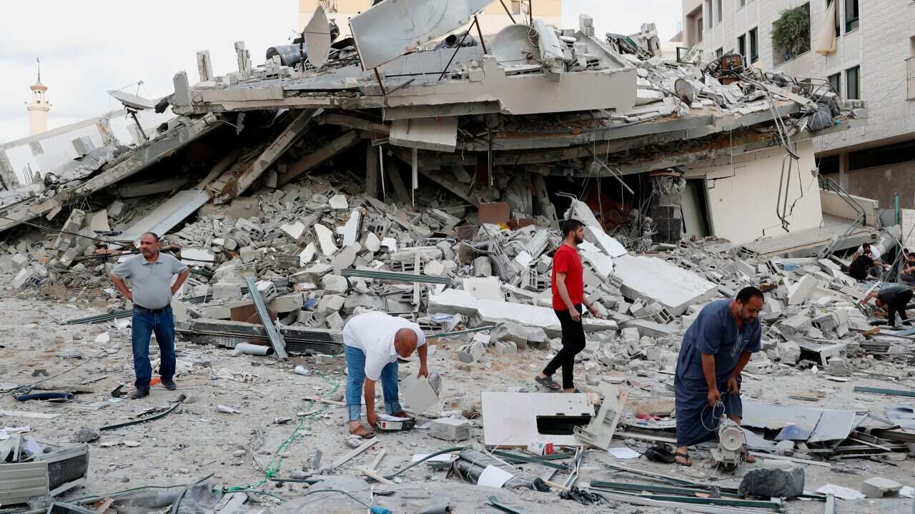 People inspect the rubble of destroyed residential building that was hit by an Israeli airstrike in Gaza City.