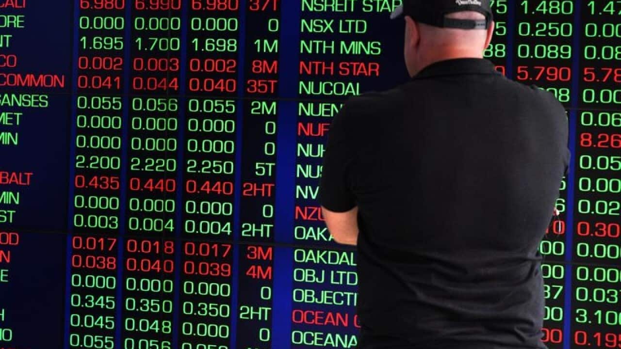 Pedestrian looks at ASX trading board.