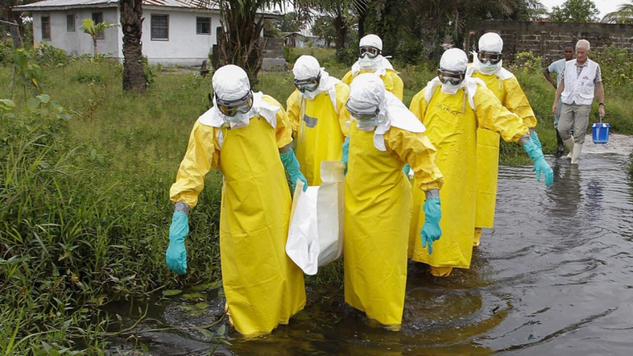 Liberian Healthcare workers prepare to bury an Ebola victim.