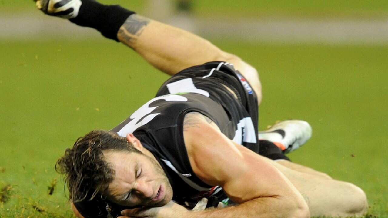 Travis Cloke of Collingwood crashes to the ground