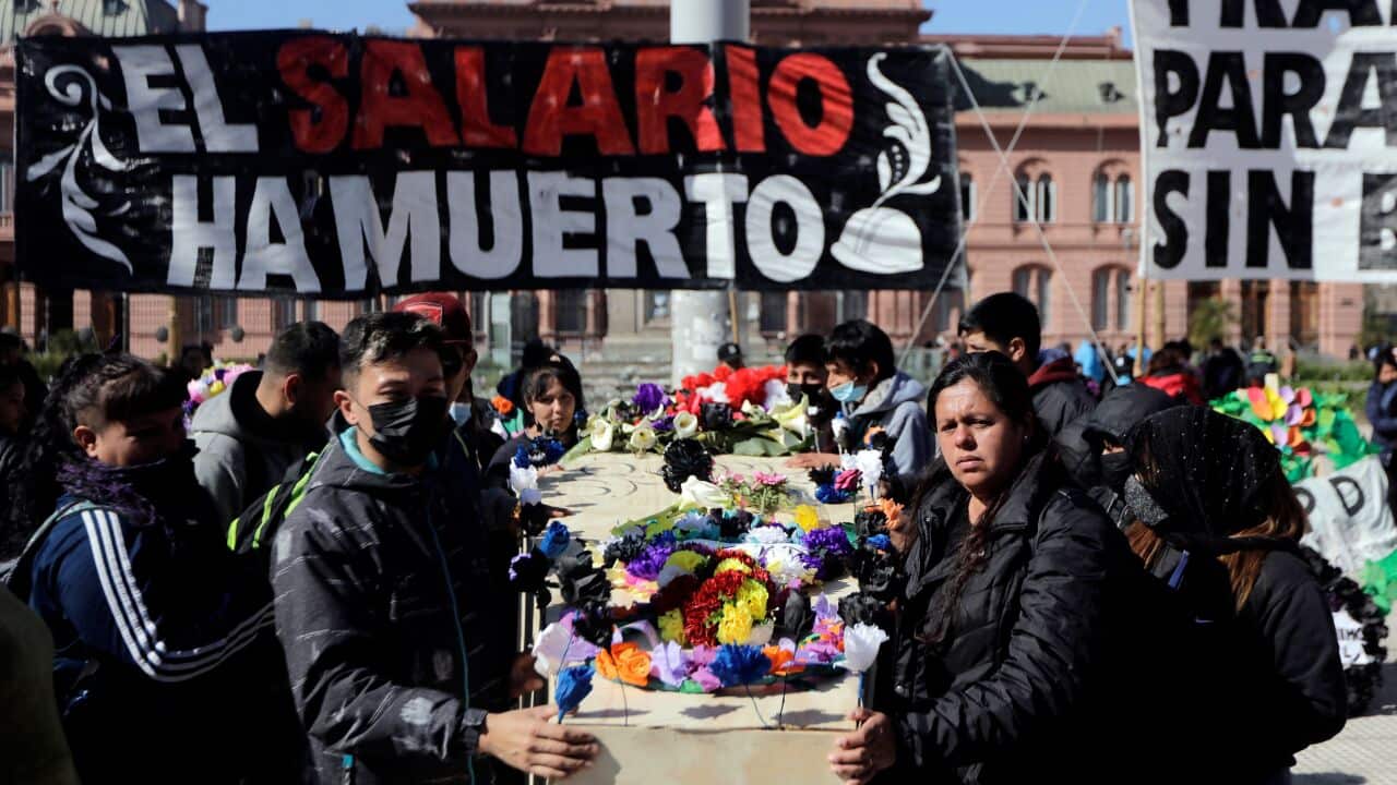 Argentinian people in a public square carrying a coffin.