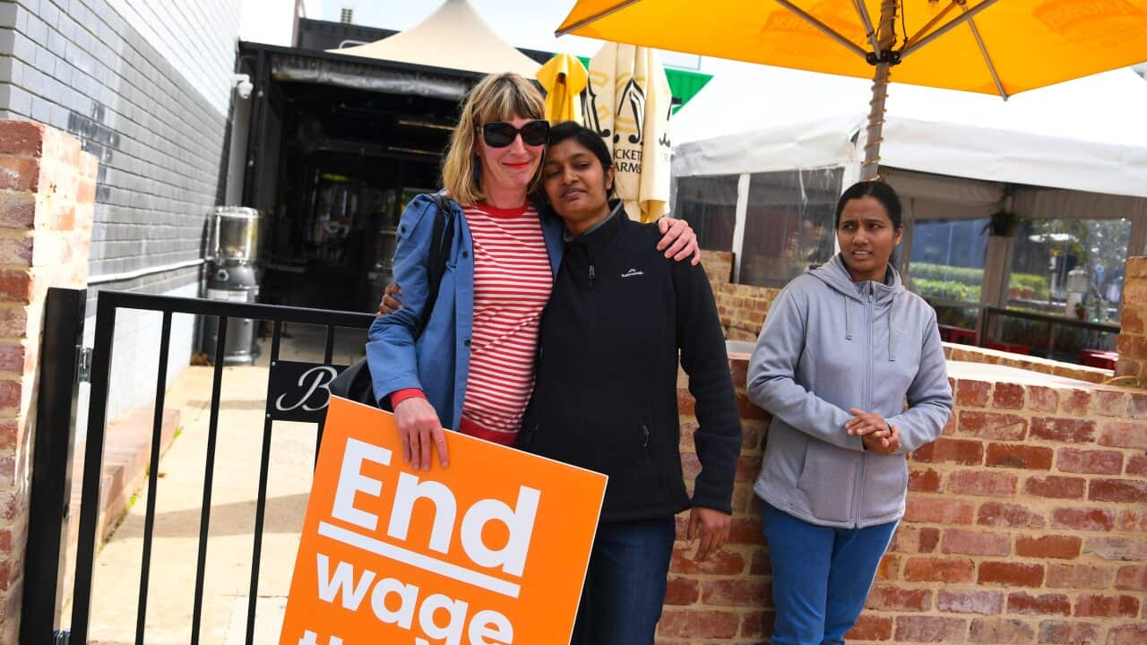 Former employees Shojin Thomas (centre) and Ninumol Abraham are seen near the Indian Restaurant Binny's Kathitto in Canberra.