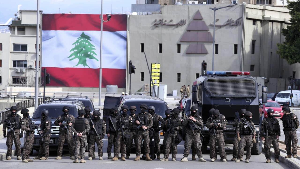 Special forces stand guard, as riot police scuffle with anti-government protesters near the parliament building in downtown Beirut