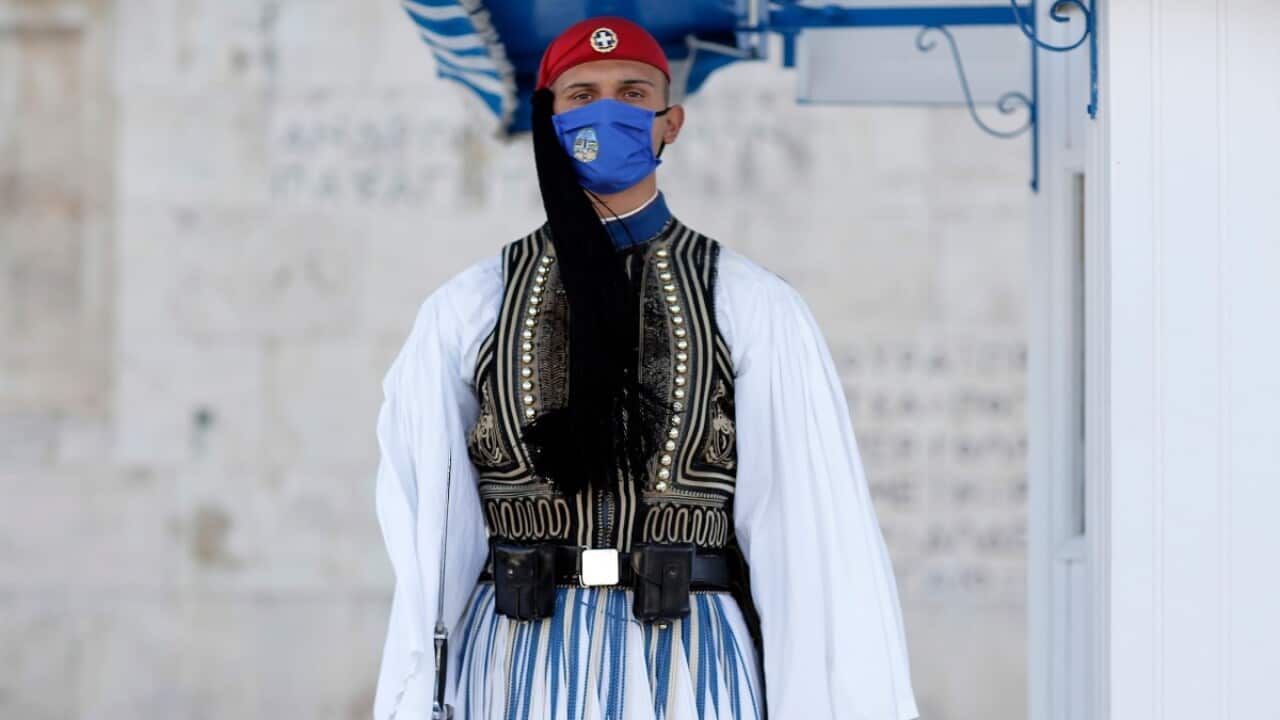 A Greek Presidential guard wearing a face mask stands at attention at the monument of the Unknown Soldier during the second lockdown of the country.