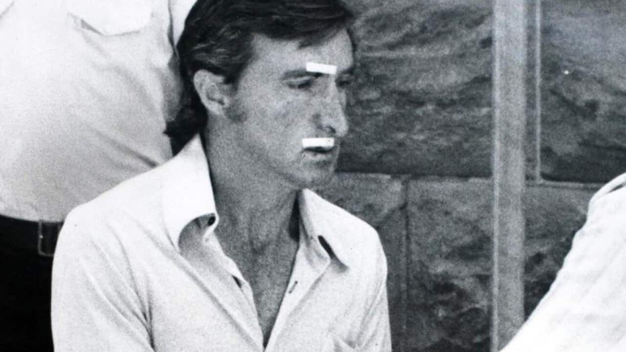 Serial killer David Birnie is led from court in handcuffs.