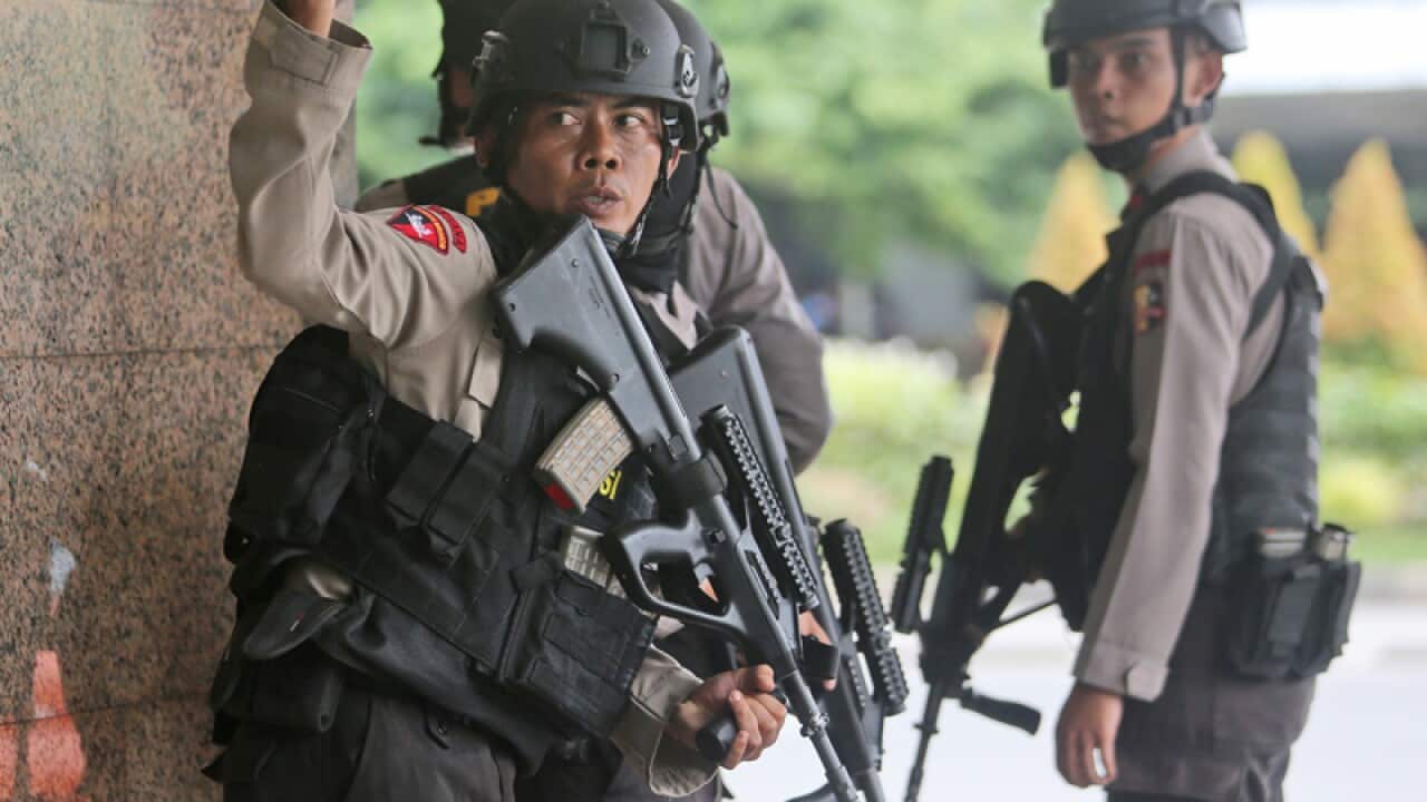 Police officers near the site of a bombing in Jakarta