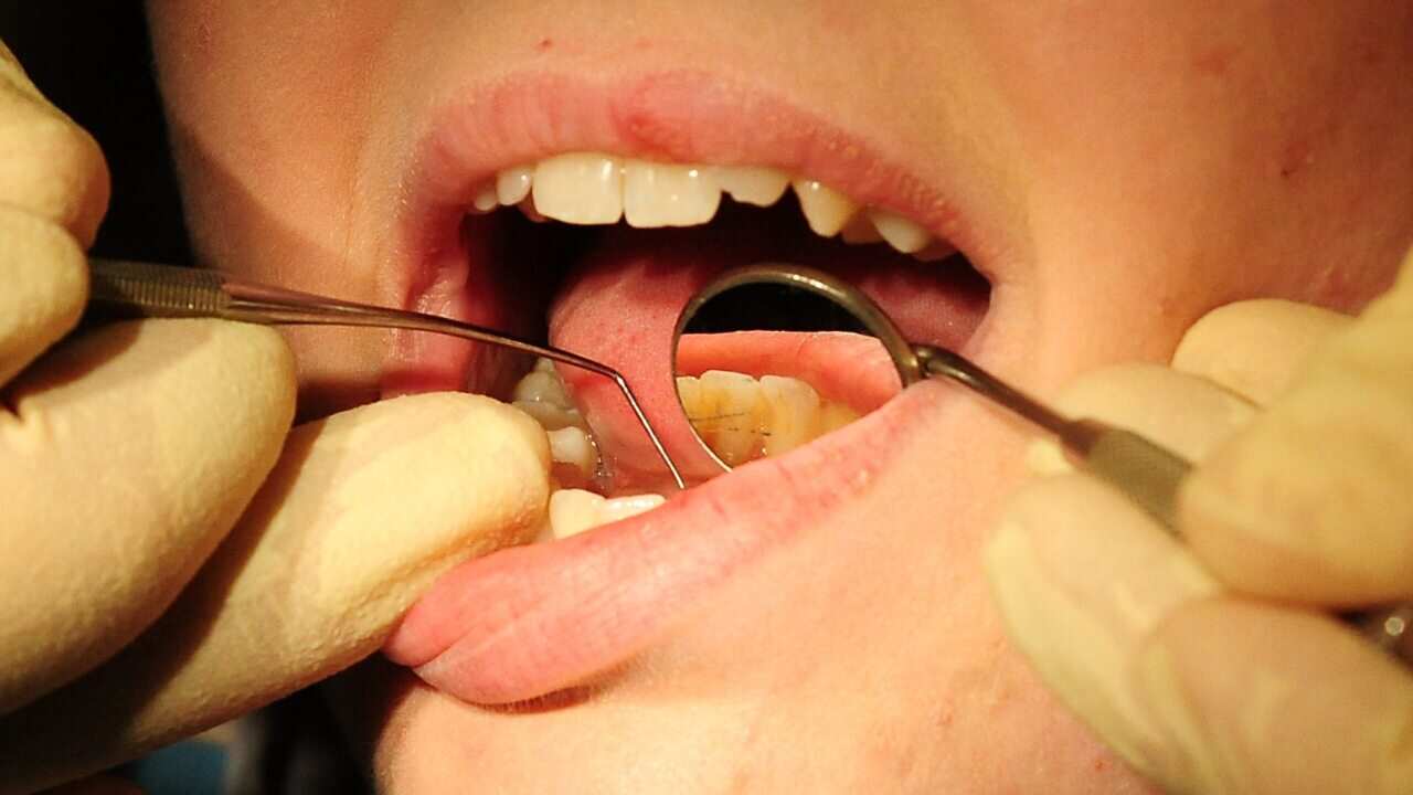 A dentist works on a patient.