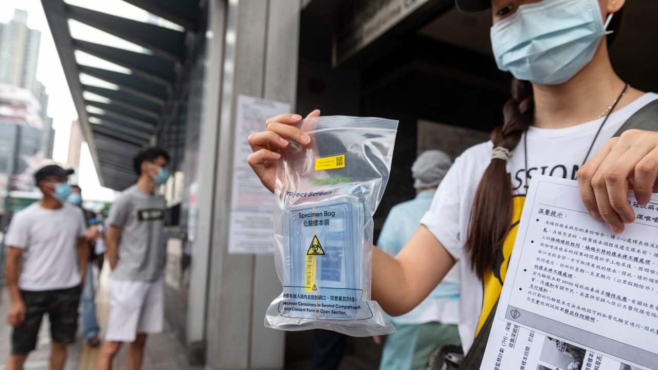 A resident shows a free COVID-19 test kit in Hong Kong (AAP)