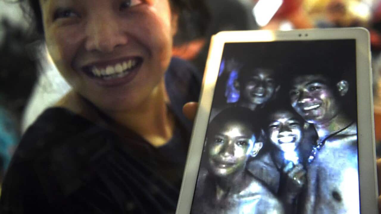 A family member shows a picture of four of the missing boys.