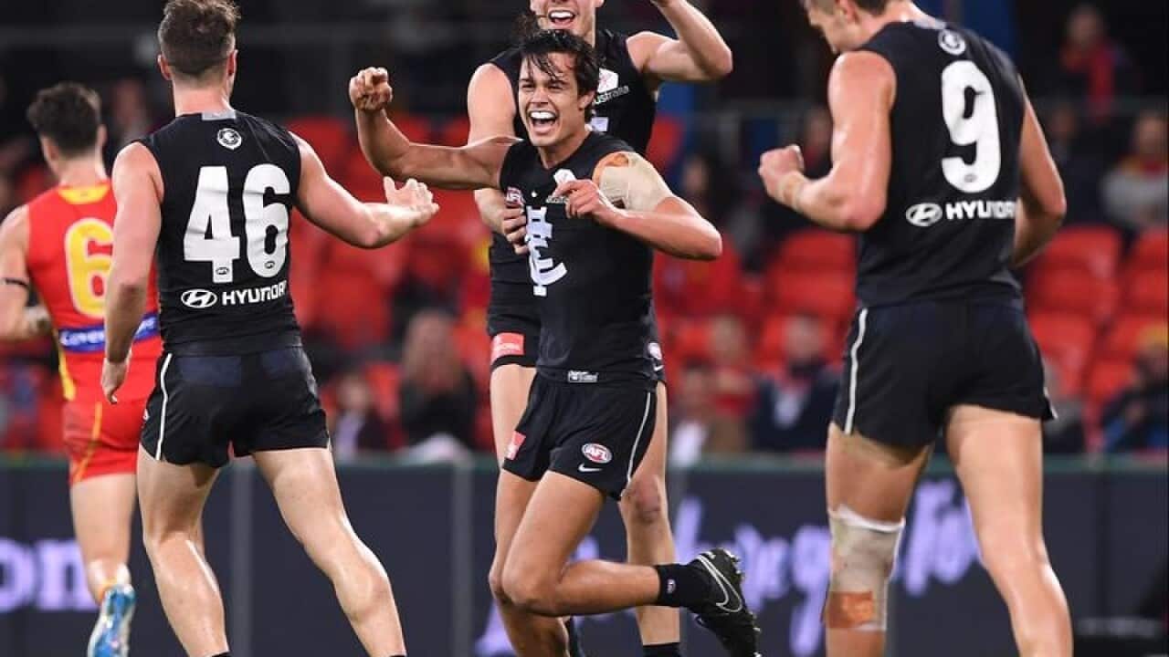 Jack Silvagni of the Blues celebrates kicking a goal with teammates.