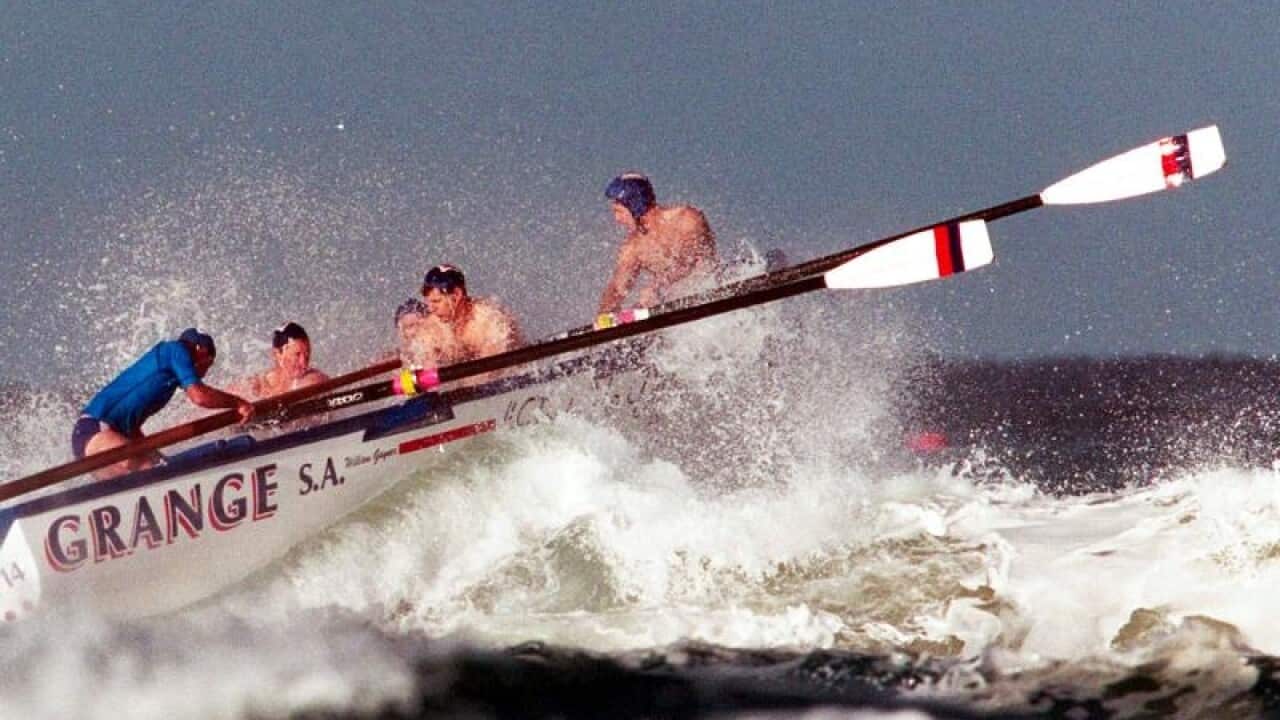 Surf lifesavers rowing a boat in rough water