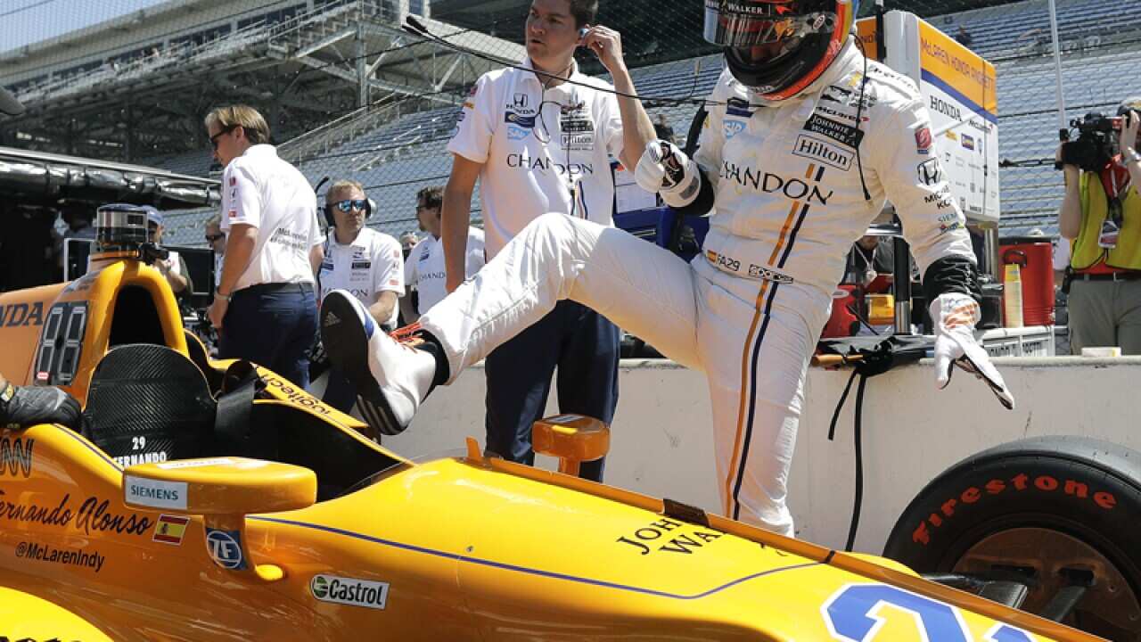 Fernando Alonso climbs into his car during a practice session