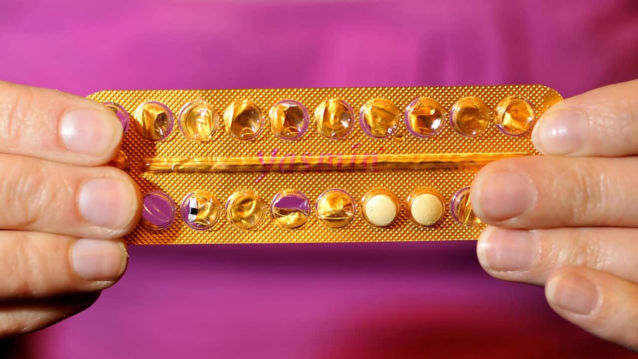 Hands holding contraceptive pills