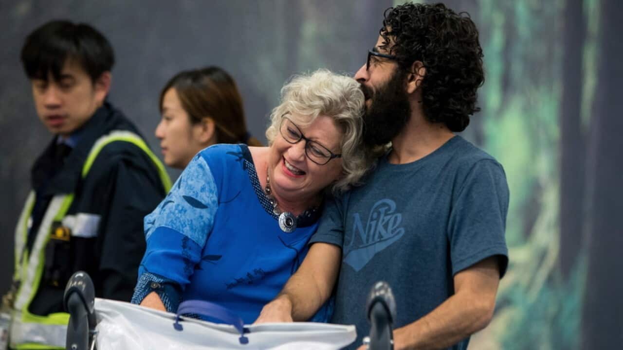 Hassan Al Kontar hugs Laurie Cooper after arriving at an airport in Vancouver