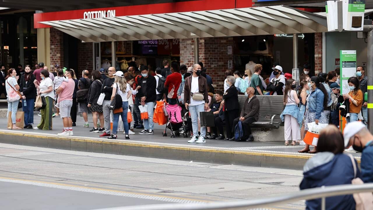 People are seen at a tram stop in Melbourne, Monday, December 27, 2021. (AAP Image/Con Chronis) NO ARCHIVING