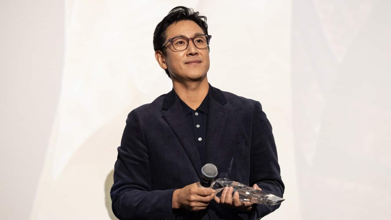 Lee Sun-kyun is seen accepting an award onstage.