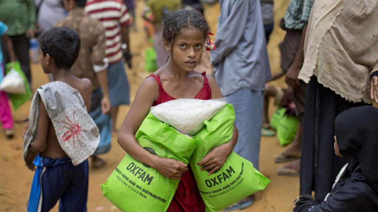 A newly-arrived Rohingya girl carries food rations in Kutupalong, Bangladesh.