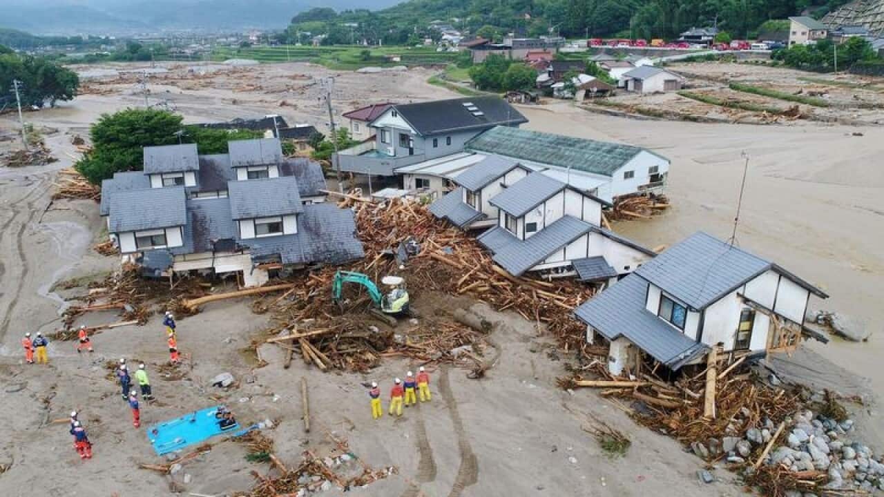 Firefighters inspect collapsed houses following flooding