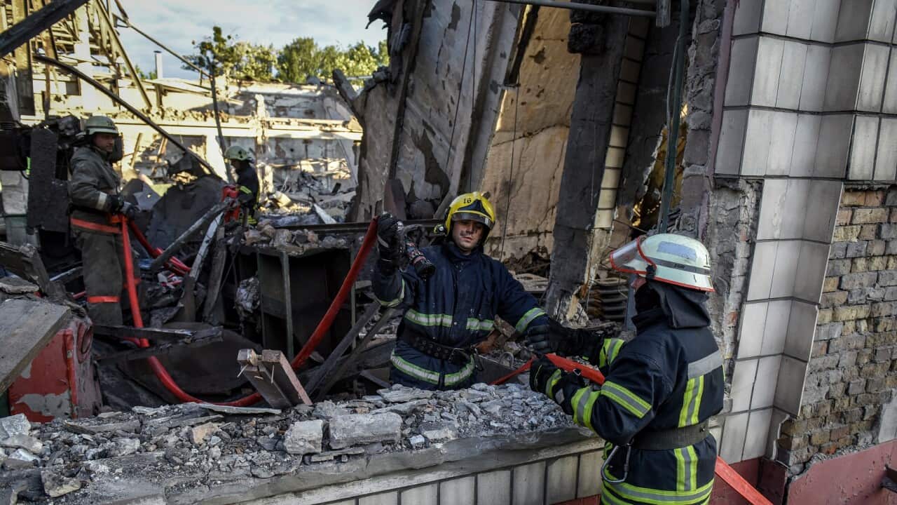 Firefighters continue to dampen down a rail freight rolling stock repair facility in Kyiv