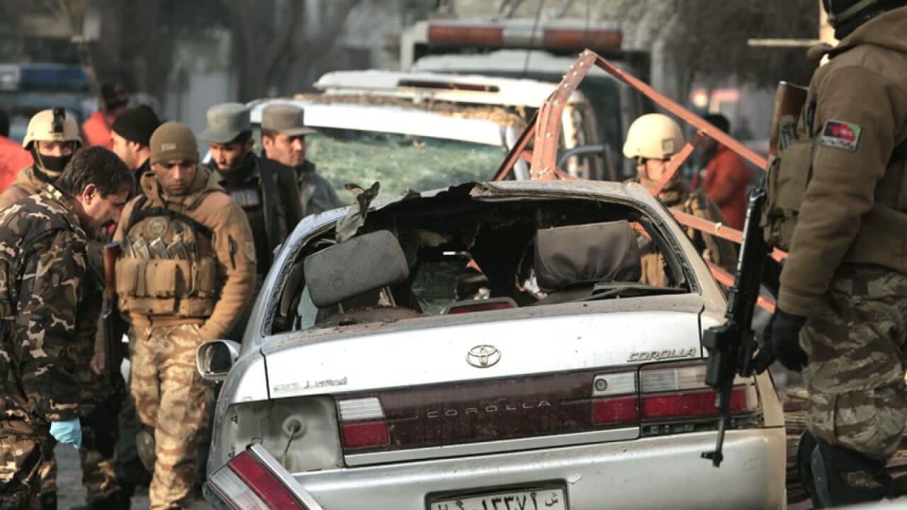Afghan security forces investigate a suicide attack in Kabul