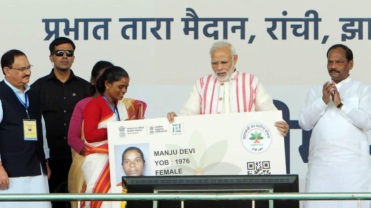 Prime Minister Narendra Modi gives a health card to beneficiaries as he launches Ayushman Bharat-National Health Protection Scheme.