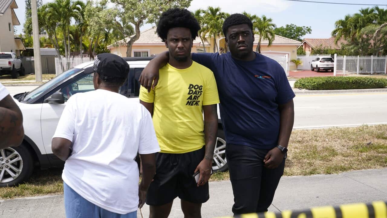 People wait for information at the scene of a fatal shooting at a banquet hall near Hialeah, Florida., Sunday, 30 May, 2021. 