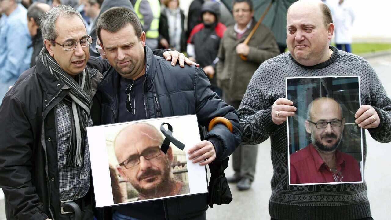 Workers from the Delphi company hold pictures of one of their two colleagues who died in the 24 March Germanwings plane crash in the French Alps (EPA/ANDREU DALMAU)