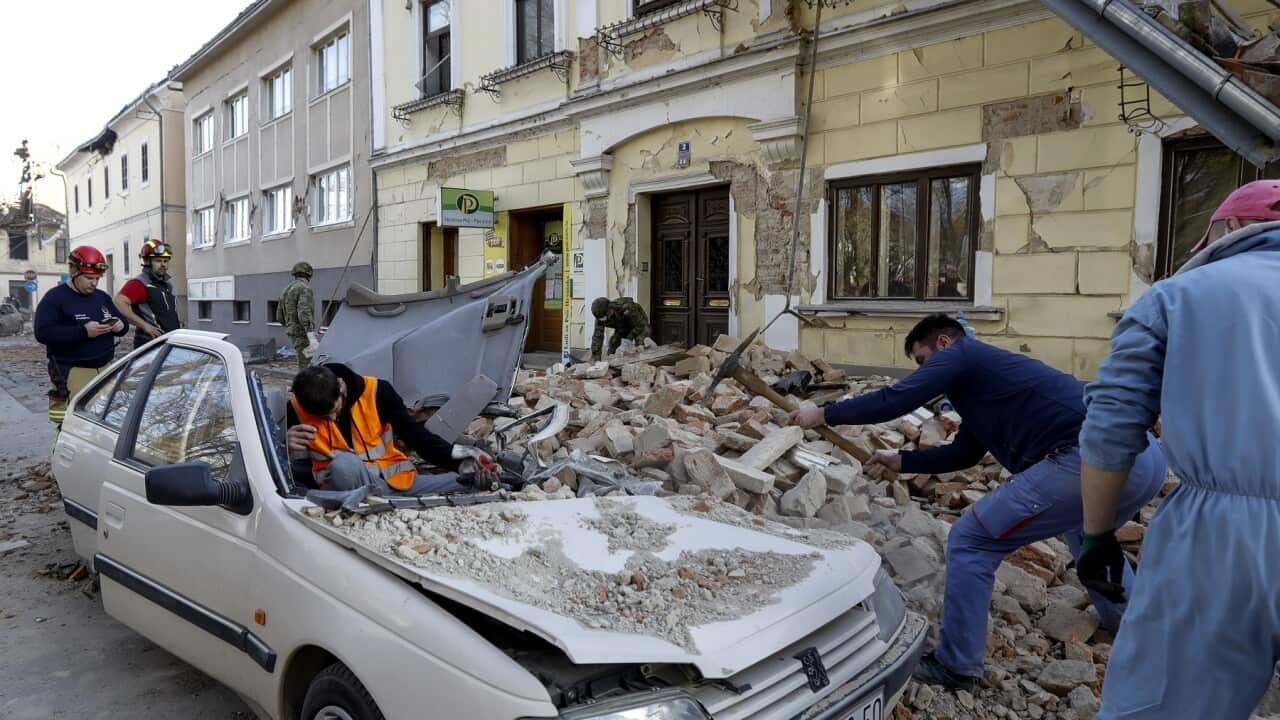 People and soldiers clean the rubble next to car and buildings damaged in an earthquake in Petrinja, Croatia, 29 December 2020. EPA/ANTONIO BAT