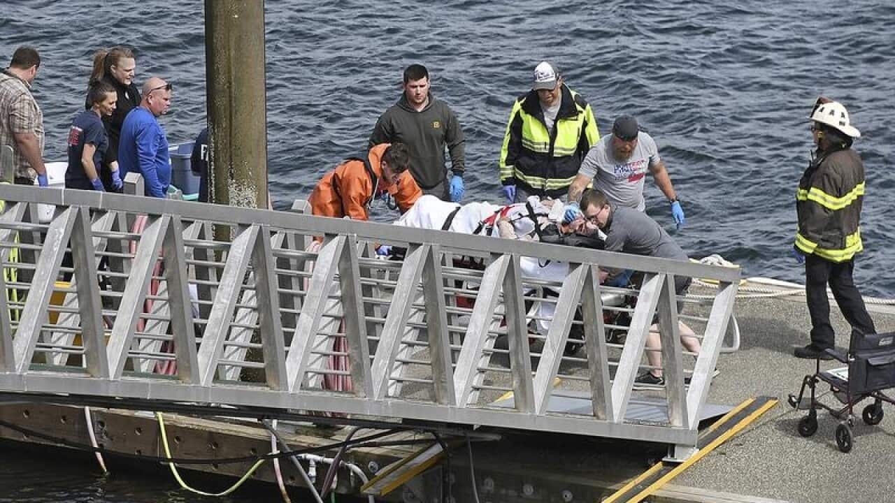 An injured passenger to an ambulance at the George Inlet Lodge docks
