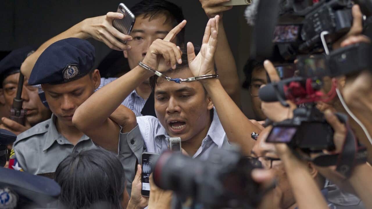 Reuters journalist Kyaw Soe Oo talks to journalists as he is escorted from court by police. 