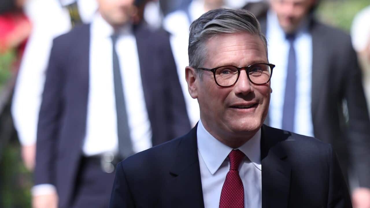 A man in a black suit with glasses