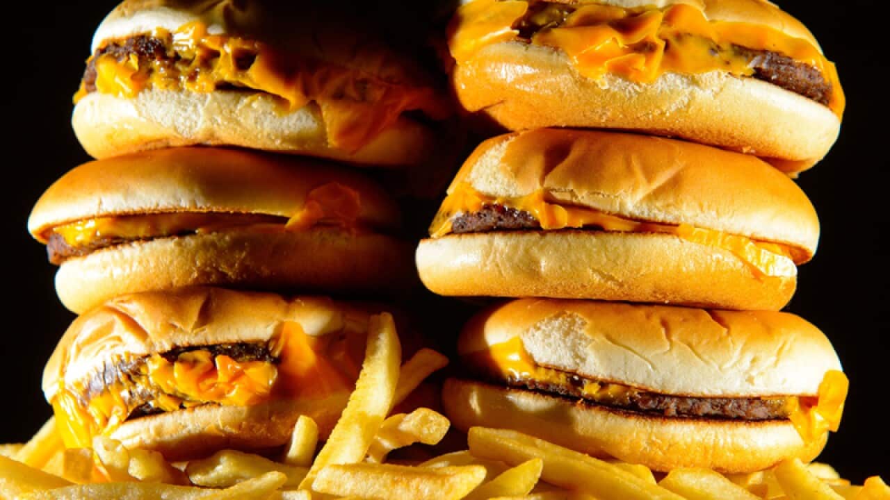 A pile of cheeseburgers and french fries