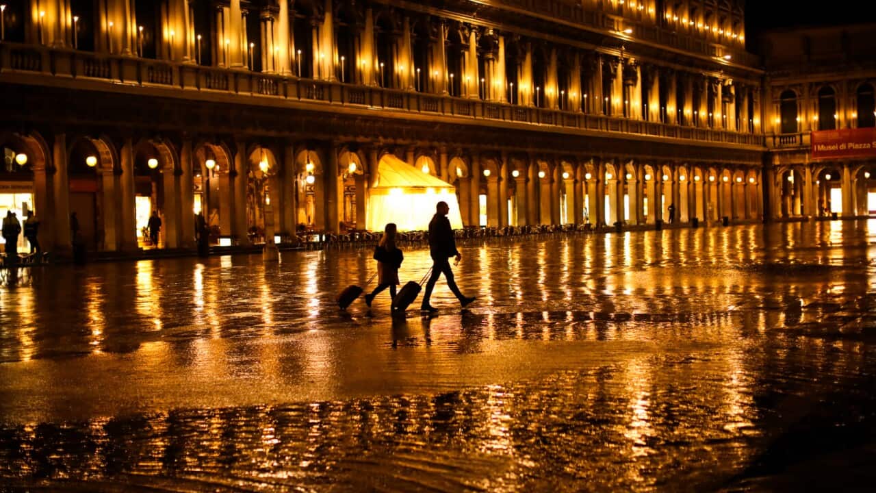 Tourista walk through nearly empty St Mark's Square
