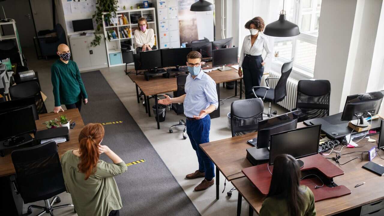 Staff meeting in office with social distancing - Getty