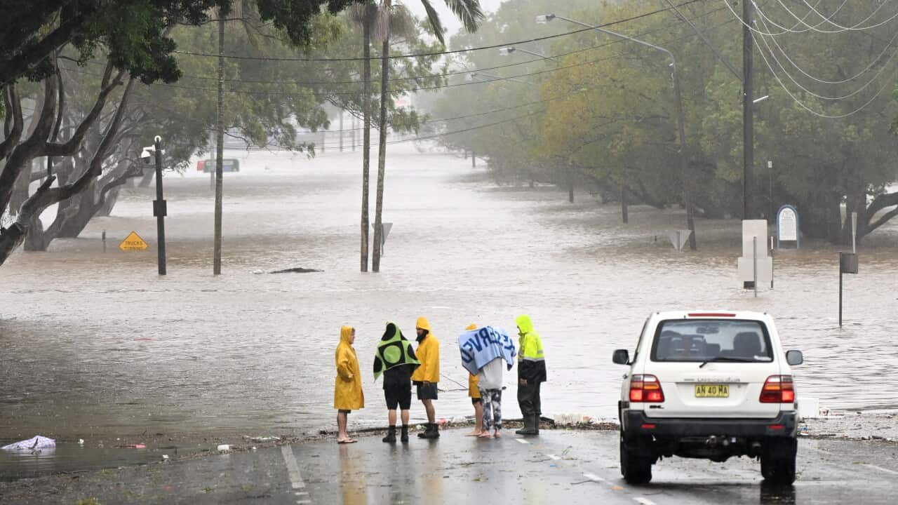 Local residents inspect a flooded road on March 30, 2022 in Lismore, Australia. Evacuation orders have been issued for towns across the NSW Northern Rivers region, with flash flooding expected as heavy rainfall continues. It is the second major flood even