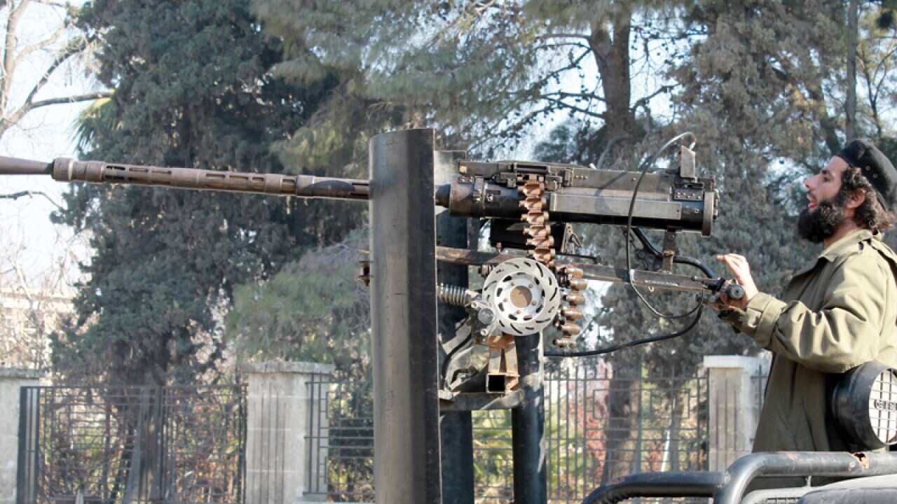 A rebel fighter aims his machine gun