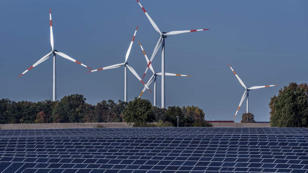 Wind turbines turn behind a solar farm in Rapshagen, Germany (AAP).