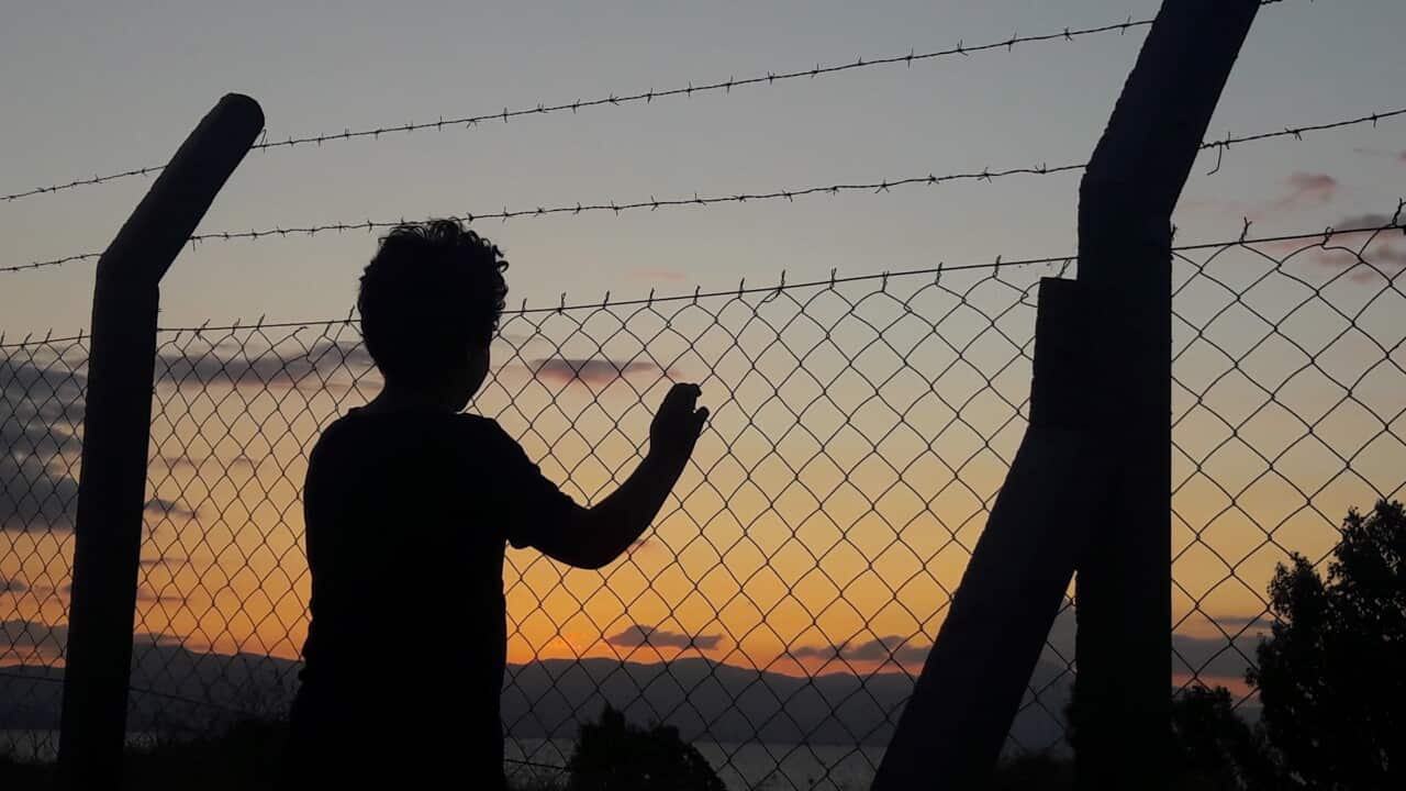 Silhouette Man Standing By Fence Against Sky During Sunset