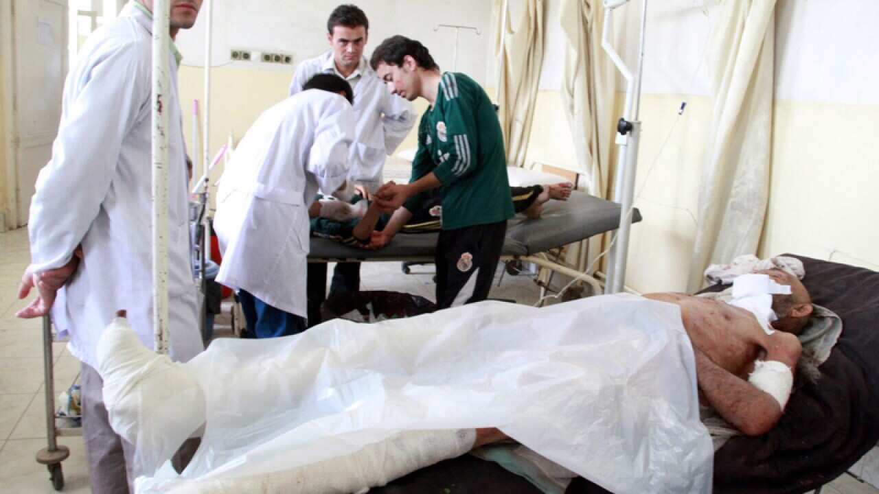 Afghan men injured in a suicide bomb blast receive treatment