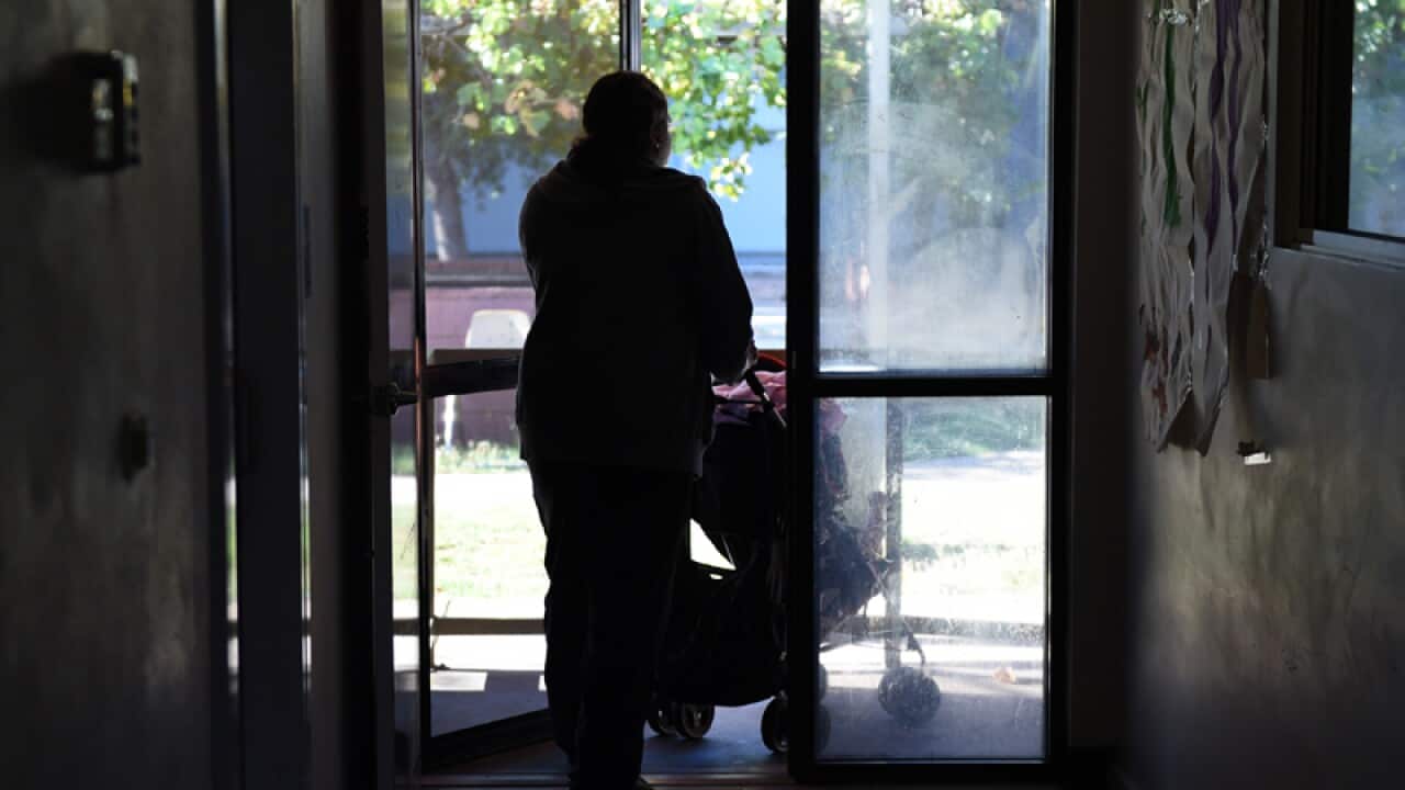 A mother pushes a pram at a women's shelter