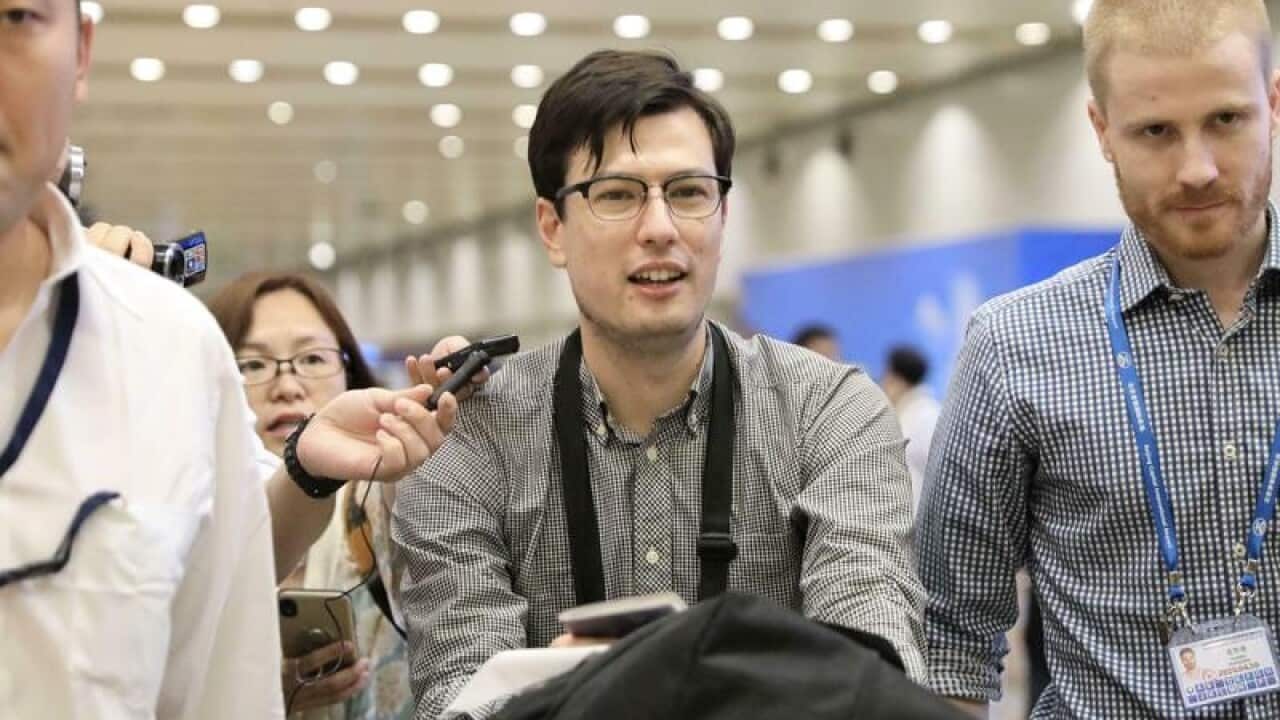 Australian student Alek Sigley smiles as he arrives at the airport.