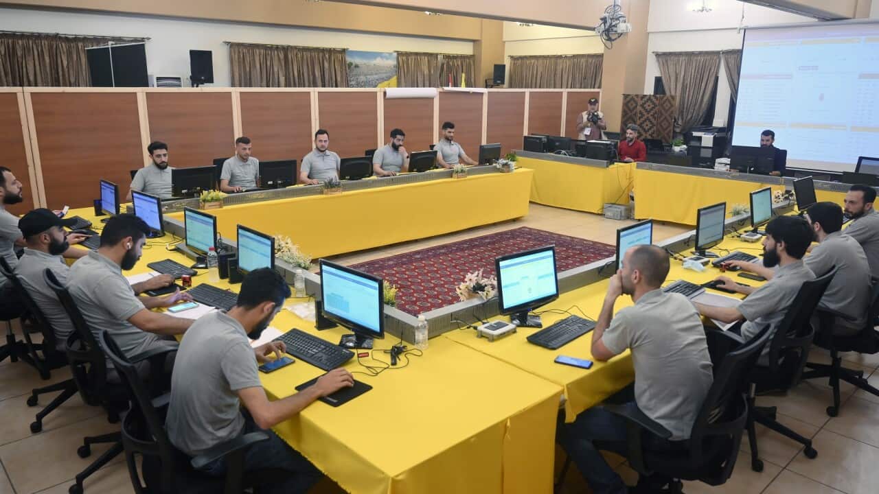 Members of Hezbollah work at the voting machine after the parliamentary elections are over