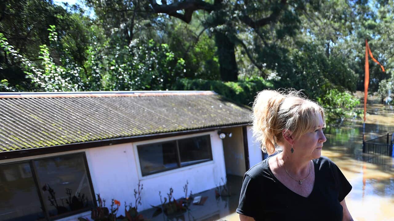 Lisa Williams looks out over her flooded backyard in Windsor in the north west of Sydney, Wednesday, March 24, 2021.