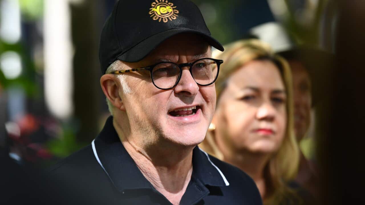 Man in polo and cap talking.